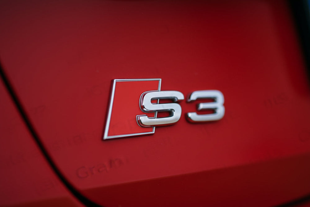 Audi S3 badge on a red car surface