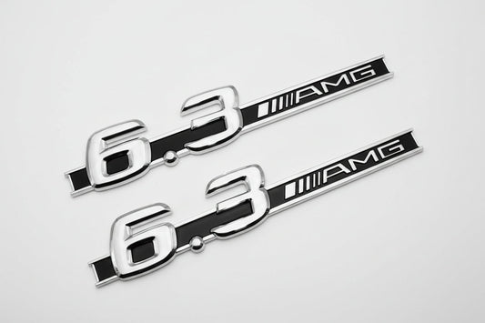 Two metallic '6.3 AMG' emblems on a white background 