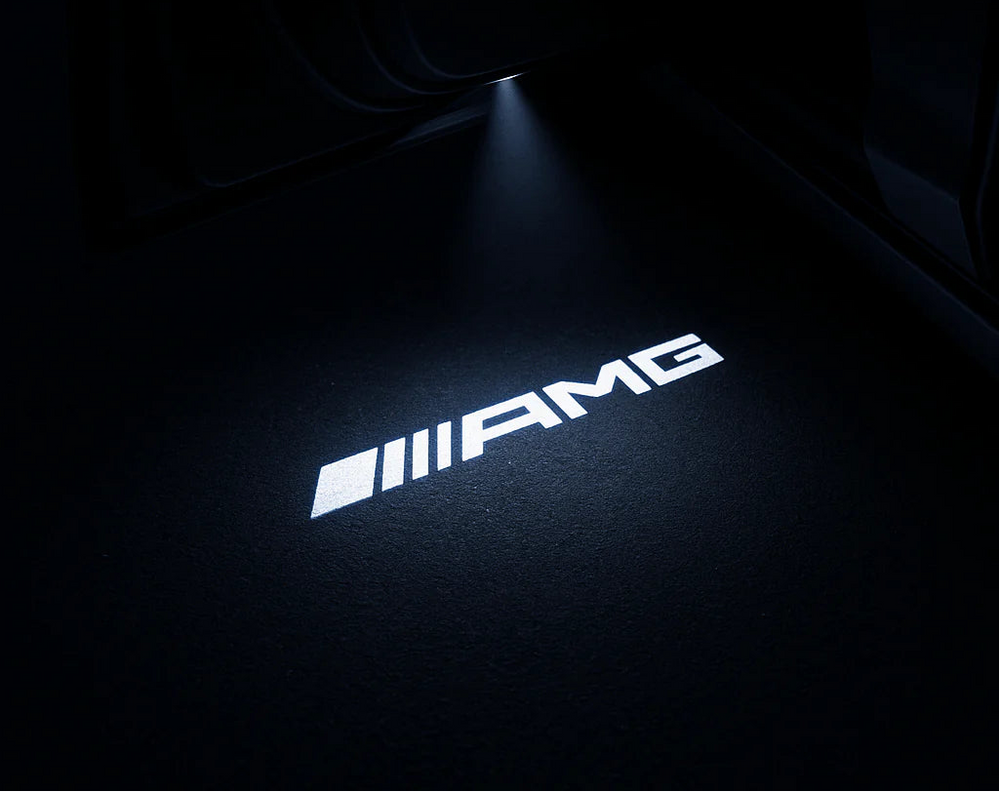 AMG logo projected onto a dark surface with a spotlight