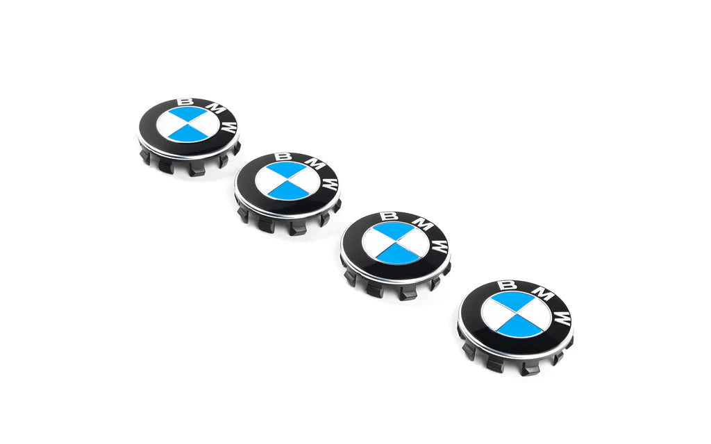 Five BMW wheel hub caps on a white background