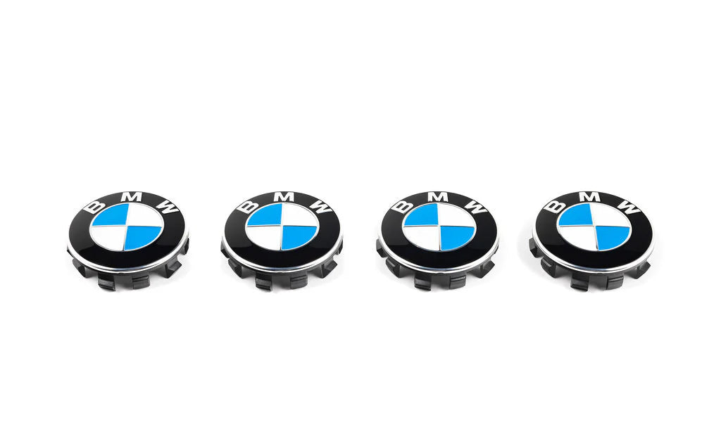 Four BMW wheel hub caps on a white background