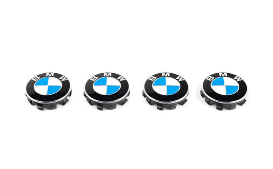 Four BMW wheel hub caps on a white background