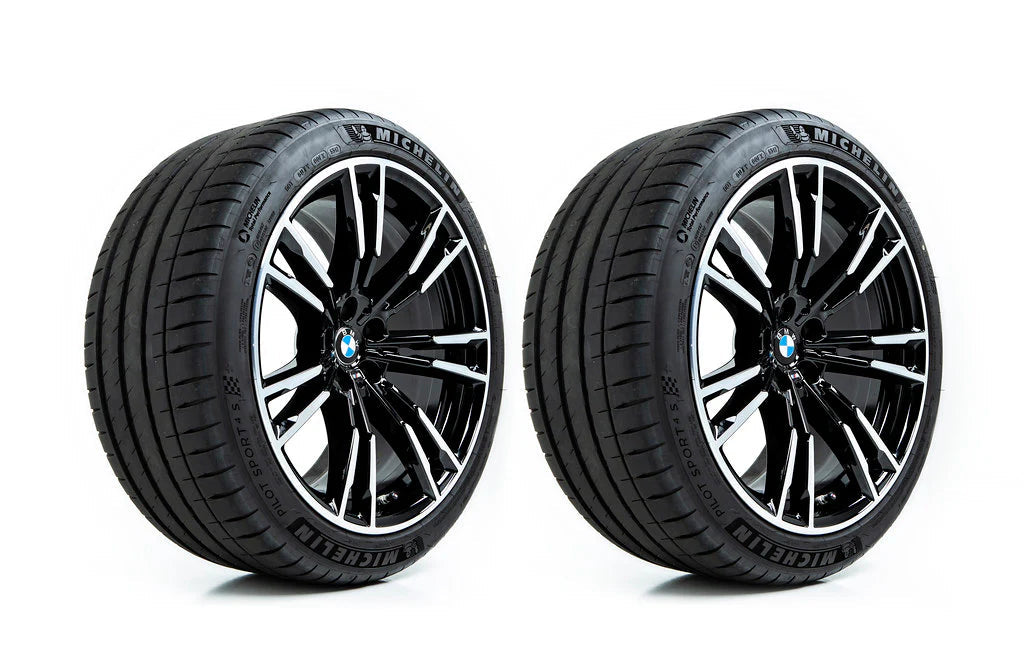 Two black BMW wheels with silver multi-spoke accents and black Michelin tires, shown side-by-side on a white background.