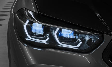 Close-up of a car headlight with illuminated blue and white LED lights, mounted on a dark gray vehicle body. F95 F96 G05 G06